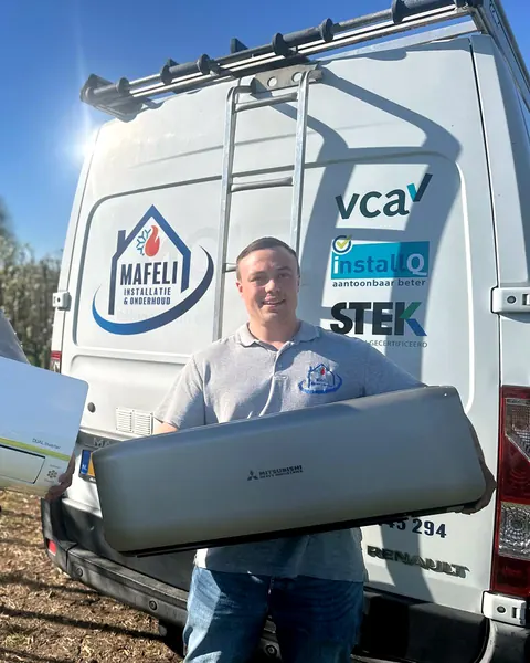 Monteur van Mafeli met een airco-binnenunit voor de Mafeli-bedrijfsbus